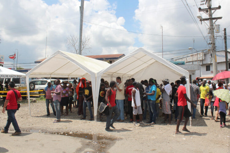 Fotografía de archivo fechada el 17 de abril de 2016 que muestra a ciudadanos costarricenses ayudando con comida y bebida a parte de los más de 500 migrantes africanos varados entre Costa Rica y Panamá en Paso Canoas (Panamá). EFE / Marcelino Rosario ARCHIVO