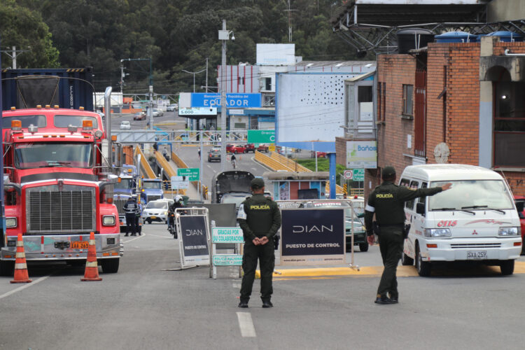 Integrantes de la Policía inspeccionan vehículos durante su paso por el puente internacional de Rumichaca, fronterizo entre Colombia y Ecuador, este viernes, en Tulcán (Ecuador). EFE/ Xavier Montalvo