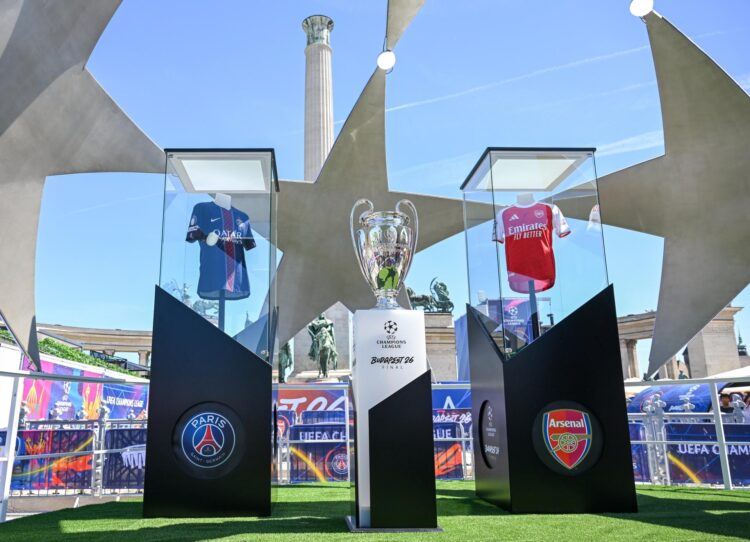 El trofeo de la Liga de Campeones expuesto entre las camisetas del Arsenal y del Paris Saint-Germain en la Fan Zone en Budapest este jueves. EFE/EPA/Tibor Illyes HUNGARY OUT