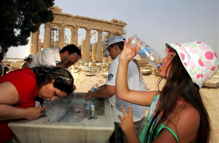 Varios turistas se refrescan durante una visita a la Acrópolis, en Atenas, en una imagen de archivo. EFE/Simela Pantzartzi