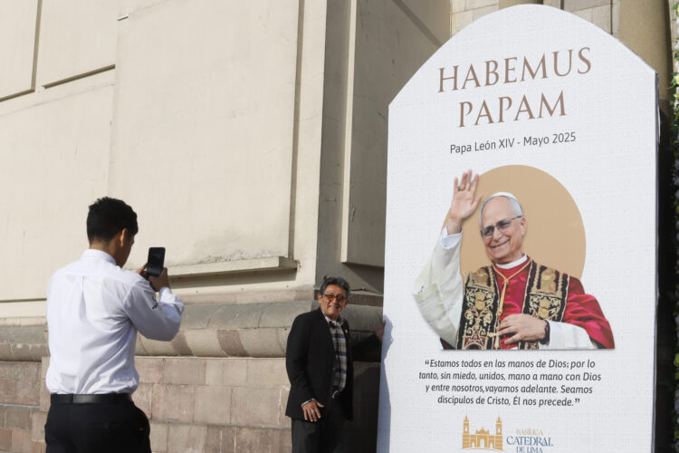 Personas se toman fotografías al lado de una imagen de León XIV en la catedral de Lima al día siguiente de su elección como papa. EFE/Renato Pajuelo