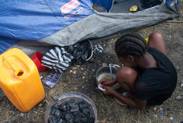 Una niña desplazada por la violencia, limpia una olla en un campamento de refugiados en Puerto Príncipe (Haití), el pasado 22 de mayo. EFE/ Jonet St Élois