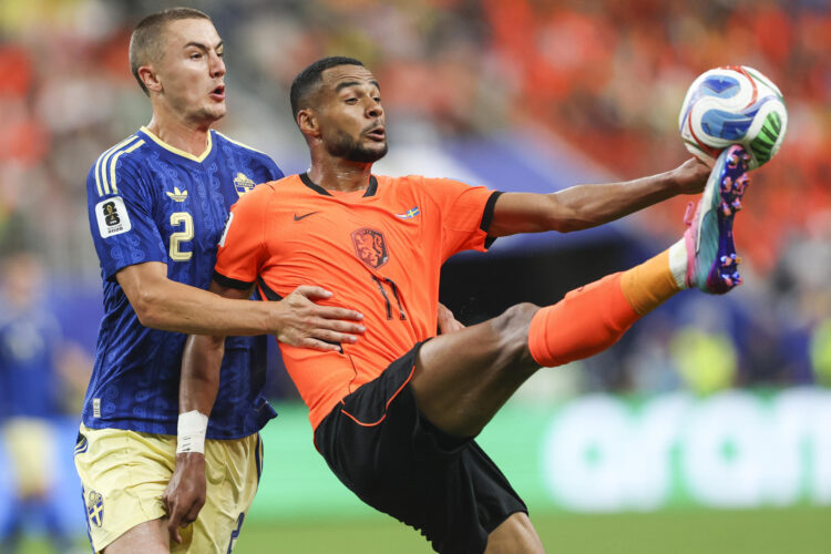 El delantero de Paises Bajos Cody Gakpo (d) disputa el balón con el defensa de Suecia Gustaf Lagerbielke durante el partido Países Bajos - Suecia del Mundial 2026 disputado este sábado en Houston.- EFE/Carlos Ramírez