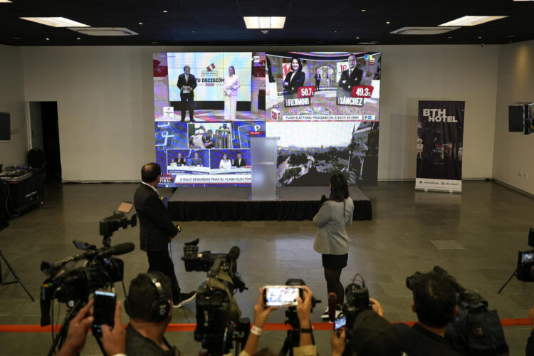 Personas observan una pantalla con los sondeos a pie de urna que muestran un empate técnico entre la derechista Keiko Fujimori y el izquierdista Roberto Sánchez durante la segunda vuelta de las elecciones a la Presidencia de Perú este domingo, en Lima (Perú). EFE/ John Reyes Mejía