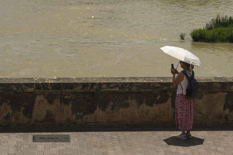 Una turista toma una foto del río Guadalquivir en Córdoba, España, este lunes. EFE/ Rafa Alcaide