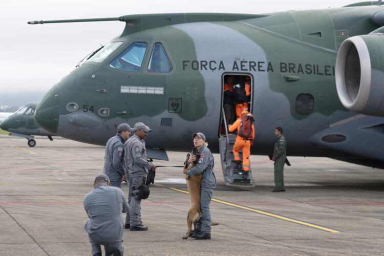 Fotografía que muestra a una integrante de la Policía Militar saludando a un canino antes de abordar un avión este viernes, en la Base Aérea de São Paulo, en Guarulhos (Brasil). EFE/ Isaac Fontana
