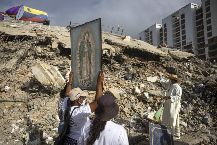 Fotografía de archivo que muestra personas junto al sacerdote Omar Pérez Gabino (d) durante un recorrido para acompañar con oraciones a familiares, voluntarios y rescatistas que continúan las labores de recuperación de cuerpos atrapados bajo los escombros tras los terremotos del pasado 24 de junio en Venezuela. EFE/ Miguel Gutiérrez
