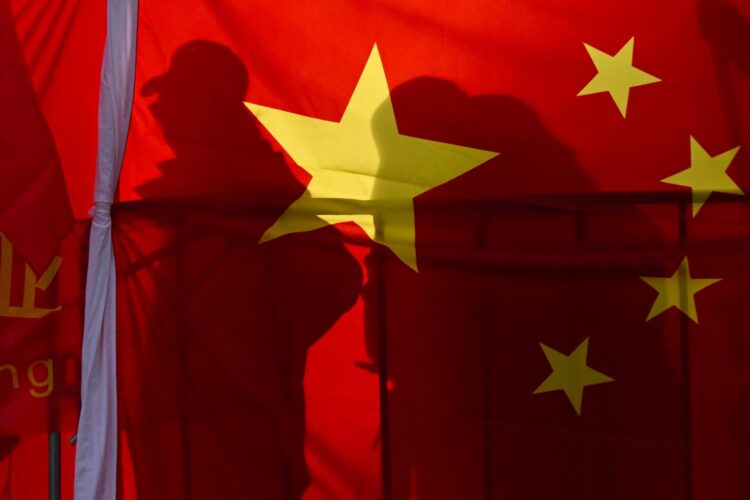 Fotografía de archivo donde aparecen dos personas tapadas por la bandera de China. 
EFE/EPA/LUKAS COCH AUSTRALIA AND NEW ZEALAND OUT