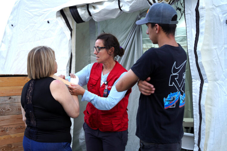 Fotografía cedida por la Agencia Española de Cooperación Internacional para el Desarrollo (AECID) que muestra a una voluntaria del grupo START (Equipo Técnico de Ayuda y Respuesta de Emergencia) coordinado por AECID (c) brindando atención a una persona durante la inauguración de un hospital este sábado, en Caracas (Venezuela).EFE/ AECID