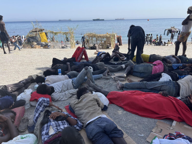 Numerosos inmigrantes permanecen en la playa del Trampolín que se ha transformado en un asentamiento desde la entrada masiva registrada a finales de julio en la ciudad Ceuta.  EFE/Reduan