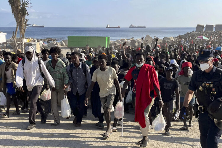 Migrantes desalojados de la playa del Trampolín en Ceuta tras habilitarse un espacio para su acogida este jueves. EFE/Reduan