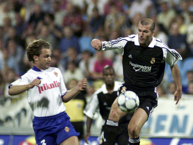 Fotografía de archivo del 19 de agosto de 2001, en la que puede verse al francés Zinedine Zidane (derecha) controlando el balón ante el zaragocista Paulo Roberto Jamelli, durante el partido de ida de la Supercopa entre el Real Zaragoza y el Real Madrid. EFE/JAVIER CEBOLLADA