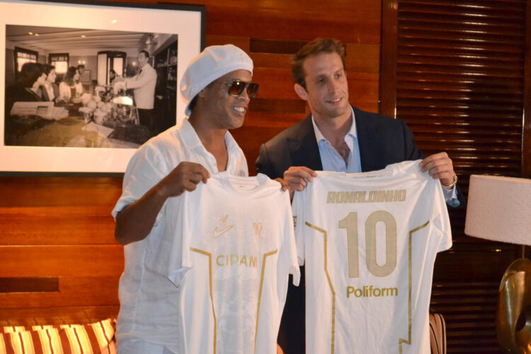 El astro brasileño Ronaldinho Gaúcho (i) y el presidente del Ravenna, Ignazio Cipriani, posan con camisetas durante el anuncio, el 15 de junio en Miami, de su regreso al fútbol profesional a los 46 años de la mano del Ravenna FC italiano. EFE/ Antoni Belchi