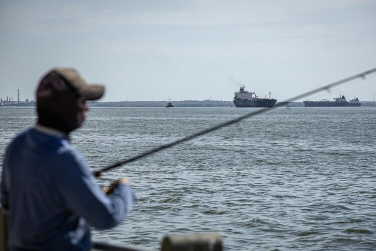 Fotografía del 29 de agosto de 2026 que muestra a una persona pescando frente un buque petrolero en Maracaibo (Venezuela).EFE/ Henry Chirinos