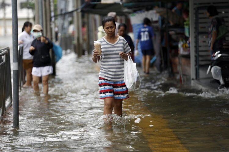 Bangkok (Tailandia), 27/09/2026.- Un residente camina por el agua tras un aguacero prolongado en una comunidad anegada de Bangkok, cuyos 50 distritos fueron declarados zonas de desastre por inundaciones tras las lluvias intensas y prolongadas. EFE/EPA/RUNGROJ YONGRIT