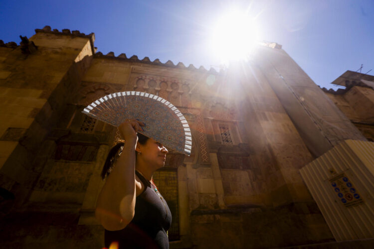 Una mujer se protege con un abanico para aliviar las altas temperaturas, en Córdoba, en una fotografía de archivo. EFE/Salas