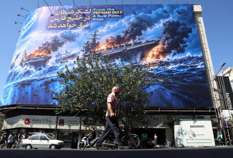 Iraníes caminan junto a una valla publicitaria antiamericana que muestra una frase en persa que dice: "El ejército del diablo se ahogará en el Golfo Pérsico", en la plaza Enghelab de Teherán, Irán, el 21 de septiembre de 2026. EFE/EPA/ABEDIN TAHERKENAREH. RESTRICCIONES: Prohibido el acceso a medios de comunicación de Israel y a cadenas de televisión en persa con sede fuera de Irán; prohibición estricta de acceso a BBC Persian, VOA Persian, Manoto TV e Iran International TV. (Según lo dispuesto por la Dirección General de Medios Extranjeros de Irán) --