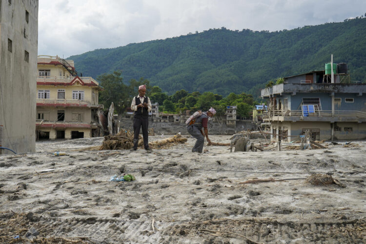 Devighat, Nepal, 31 de agosto de 2026, tras la riada. El torrente sepultó secciones enteras de esta aldea del centro de Nepal bajo metros de lodo, piedras y escombros; ahora la gente camina sobre lo que antes eran calles y, en algunos lugares, los techos de las casas están prácticamente a la altura de sus pies. Las casas yacen bajo tierra y, en algunos casos, también los muertos. EFE/Lucía Goñi