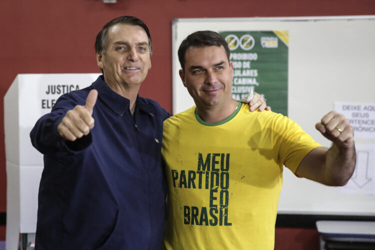 Fotografía de archivo del 7 de octubre de 2018 que muestra al expresidente de Brasil, Jair Bolsonaro (i), posando junto a su hijo, Flavio Bolsonaro, después de la primera vuelta de las elecciones presidenciales de Brasil en 2018, en Rio de Janeiro (Brasil). EFE/ Antonio Lacerda/ ARCHIVO