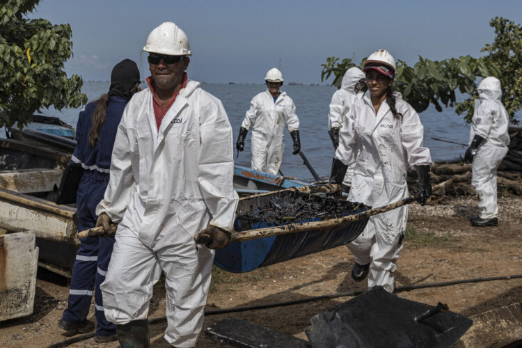 Empleados públicos trabajan en una jornada de limpieza de petroleo este martes, en el Lago de Maracaibo en Bachaquero (Venezuela). EFE/ Henry Chirinos