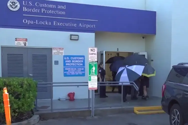 Captura de video que muestra a personas cubriendo con sombrillas al excandidato presidencial brasileño Flávio Bolsonaro a su llegada este miércoles al Aeropuerto Ejecutivo de Miami-Opa Locka en Miami (EE UU). Foto: EFE/ Antoni Belchi